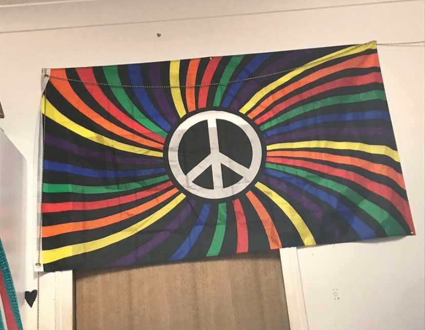 Rainbow Peace Flag hung on a bedroom wall