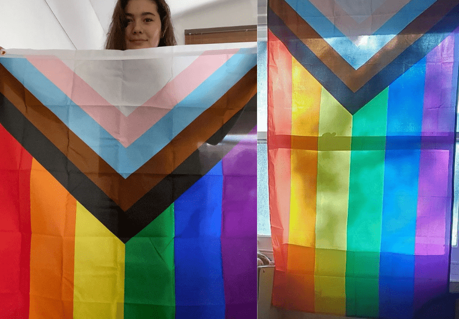 Person looking through the Progress Pride Flag held in their hands, showing the chevron stripes and rainbow detail