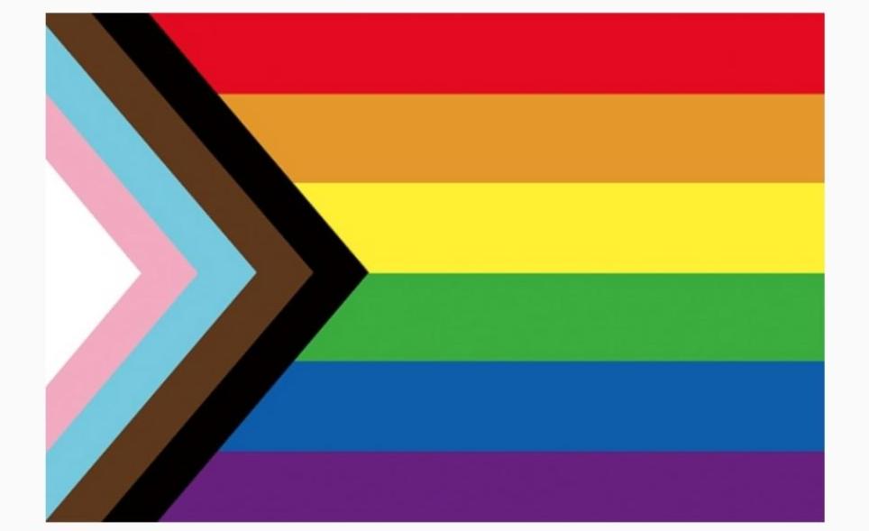 Progress Pride Flag — Daniel Quasar's 2018 design featuring the rainbow Pride flag with a forward-pointing chevron of black, brown, light blue, pink, and white stripes representing LGBTQ+ people of color and the transgender community